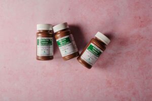 Three brown bottles of magnesium tablets on a soft pink background, ideal for health-themed content,was passiert wenn man zu viel magnesium nimmt