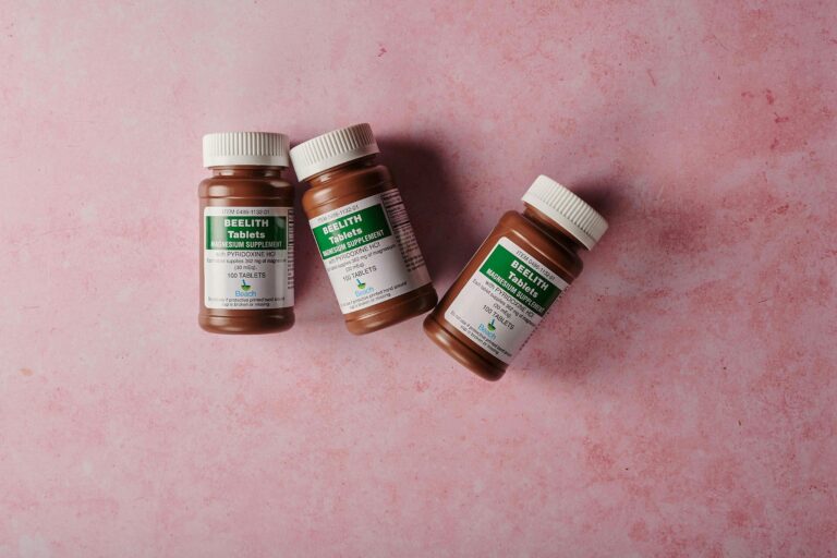 Three brown bottles of magnesium tablets on a soft pink background, ideal for health-themed content,was passiert wenn man zu viel magnesium nimmt